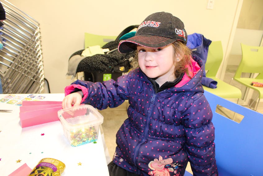 Ava Morris checks out the craft table glitter at Chinese New Year celebrations at the Inspire Learning Centre Feb. 5.