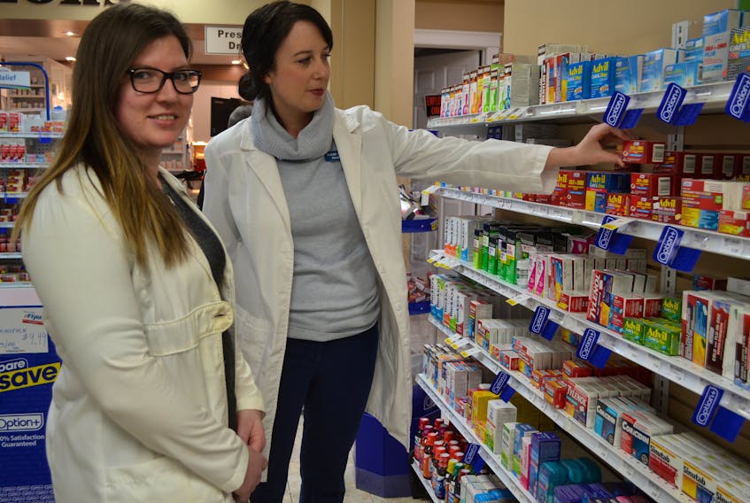 Alberton Pharmacy pharmacists Alicia O’Halloran, left, and Naomi Lynde show some of the over-the counter medications people often turn to when fighting the flu. There are also prescription drugs available that help shorten the symptoms of the flu and minimize complications, they note.