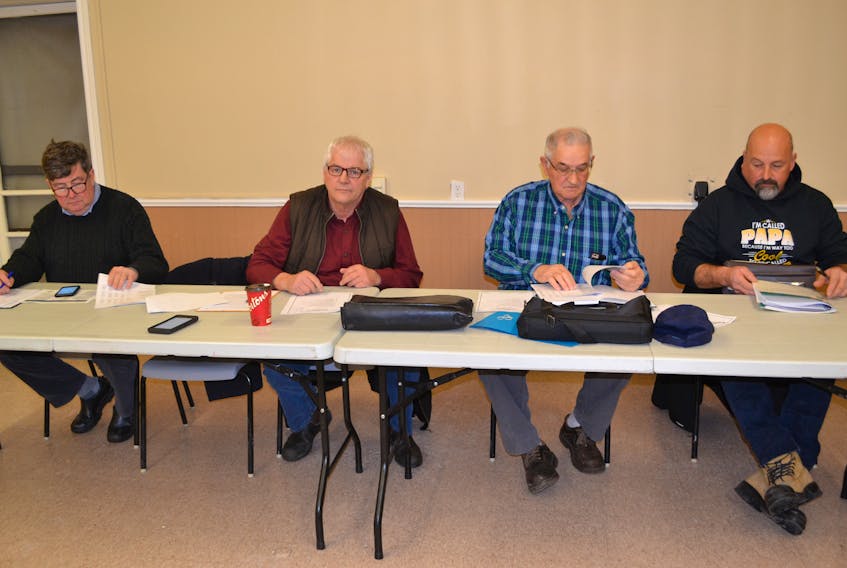 P.E.I. Fishermen’s Association managing director, Ian MacPherson, from left, PEIFA president Bobby Jenkins and Prince County Fishermen Association directors Shelton Barlow and Mike Myers review reports during the PCFA’s annual meeting Tuesday in O’Leary.