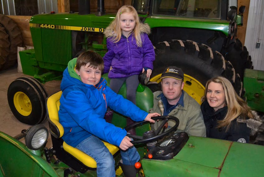 Luke and Mary Rogers proudly take a seat on one of Picturesque Farms’ tractors. Farm owners Justin and Laura Rogers, their parents, were recently named Atlantic Canada’s Outstanding Young Farmers. They grow seed grains and raise beef cattle on their farm in Brae.