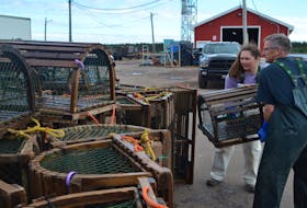 Captain Michael Shea and his daughter, Ashley, pile lobster traps onto the wharf in Northport Tuesday. The season ends Wednesday, but the Sheas were determined to finish landing all of their gear a day early.