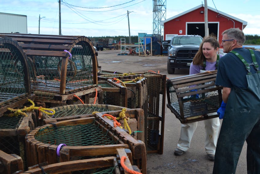 Captain Michael Shea and his daughter, Ashley, pile lobster traps onto the wharf in Northport Tuesday. The season ends Wednesday, but the Sheas were determined to finish landing all of their gear a day early.