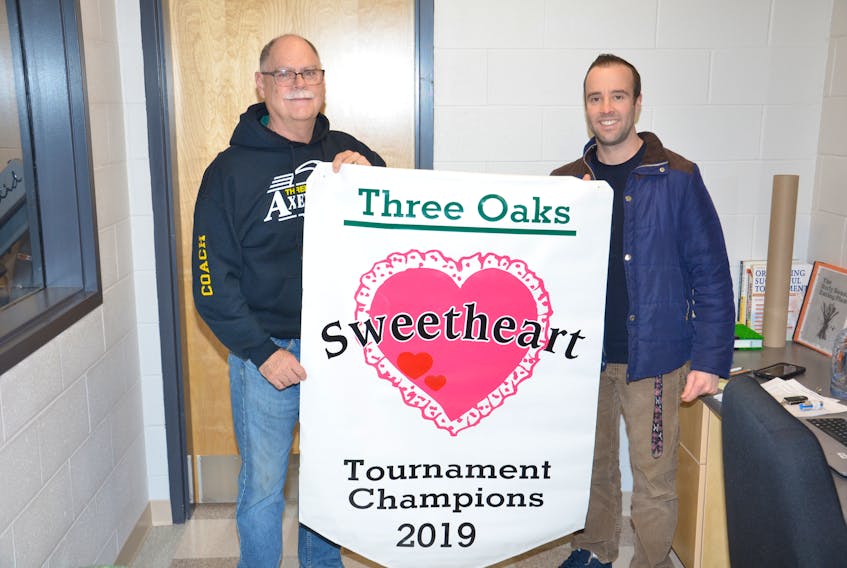Three Oaks Axewomen head coach Garth Turtle, left, and Three Oaks Senior High School athletic director Joel Arsenault display the championship banner up for grabs at this weekend’s 38th Sweetheart senior girls’ basketball tournament. Play begins Friday evening, and the championship game is Saturday at 3 p.m.