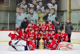 The Summerside Capitals pose with the championship trophy for the 21st annual Edd McNeill Memorial hockey tournament at The Plex in Slemon Park on Sunday afternoon. Team members are, front row, from left: Cole Echlin and George Gallant. Middle row: Josh Pridham, Carson Griffin, Ethan Dickson, Alex Gaudet, Cyrus Cormier, Grayson Arsenault, Brian Zhang, Ashton Brown and Andrew Thompson. Back row: Nick Heer (assistant coach), Brewer Waugh, Emmalee McGuigan, Griffin Ryan, Cam Schurman, Link Waugh (captain), Will Murphy, Andrew Griffin (head coach) and Trent Smith (assistant coach). The Capitals edged Nova Scotia’s West Hants Warriors 4-3 in the championship game.
