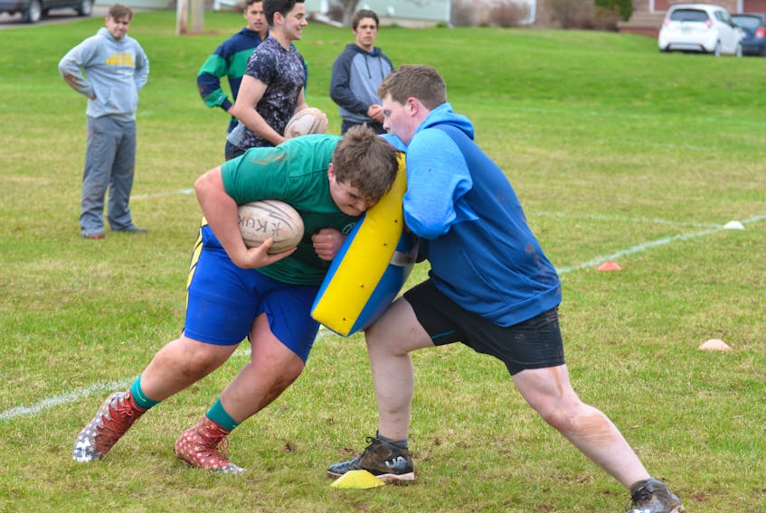 Ryan Murphy, left, and Sean Lawlor compete in a drill during a recent practice for the Three Oaks Axemen senior AAA boys’ rugby team. The Axemen are hosting the 22nd annual David Voye Memorial rugby tournament later this week.