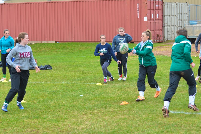 Mackenziee Crockett, wearing MUN sweater, makes a pass to Maddy Clements during a practice for the Three Oaks Axewomen’s senior AAA rugby team. The Axewomen will compete in the Summerside high school’s 22nd annual David Voye Memorial rugby tournament this weekend.