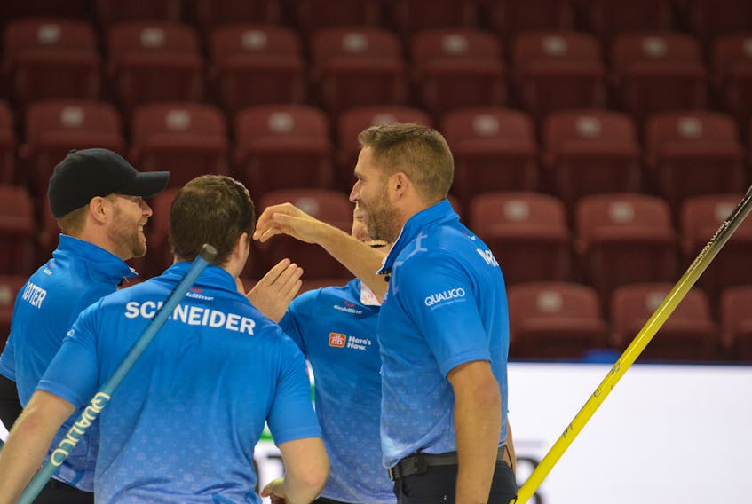 Skip John Morris, right, and third stone Jim Cotter are about to embrace moments after clinching a berth in the Tim Hortons Roar of the Rings in Ottawa next month. Second stone Catlin Schneider and lead Tyrel Griffith also celebrate.