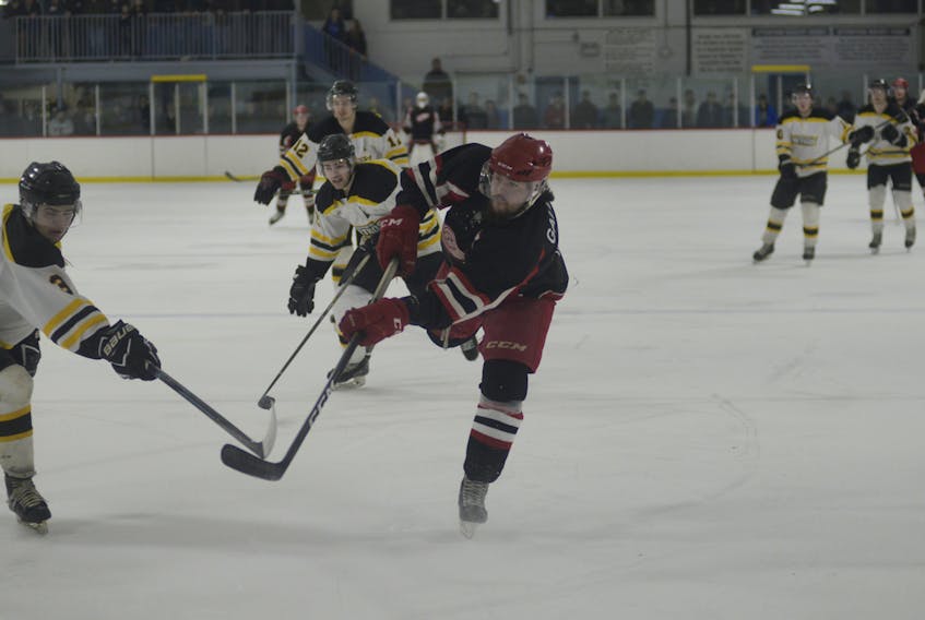 Western Red Wings captain Chasse Gallant fires a shot on goal as Sherwood-Parkdale Metros defenceman Alex Hall tries to get his stick in the way Sunday during Island Junior Hockey League playoff action in Charlottetown.