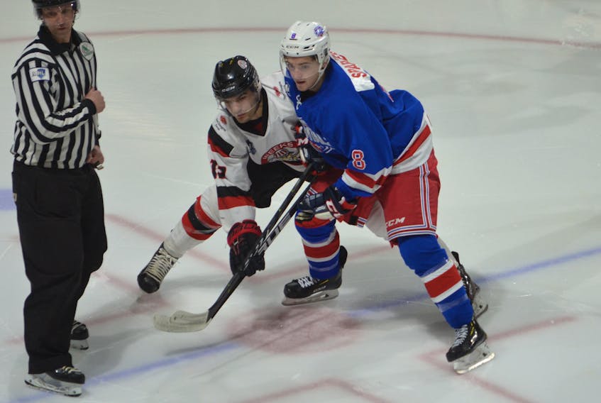 The Pictou County Crushers’ Evan Gallant, left, of Abram-Village and Sullivan Sparkes of the Summerside Western Capitals track the puck following a faceoff in the first period of Wednesday night’s MHL (Maritime Junior Hockey League) game at Eastlink Arena. The Capitals won the game 6-3.