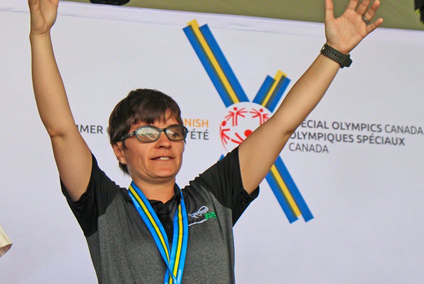 Teri Cudmore of Charlottetown raises her arms in the air after being presented with the silver medal for the 100 metres at the Special Olympics Canada 2018 Summer Games in Antigonish, N.S., on Saturday.