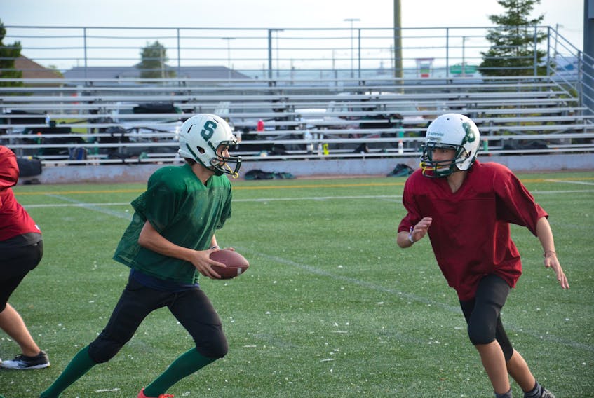 Summerside Spartans quarterback Lucas Doucette hands the ball off to Ryan McCourt during a drill in a recent practice at Eric Johnston Field. The Spartans open the P.E.I. Bantam Tackle Football League season against the Kings County Steelers at Eric Johnston Field on Friday at 6 p.m.