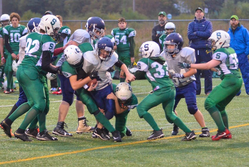 Members of Summerside Spartans’ defence tackle the Charlottetown Privateers’ Jared Watts during a P.E.I. Bantam Tackle Football League game at Eric Johnston Field in Summerside on Friday evening. The Spartans won the game 38-16 to improve to 3-0 (won-lost).