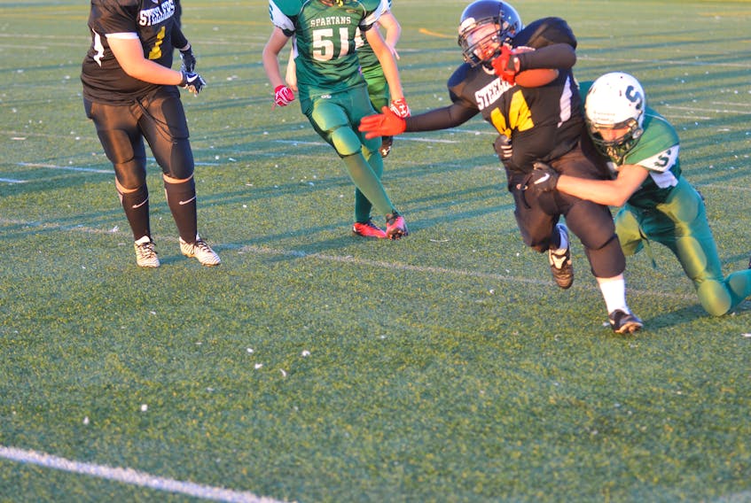 Aiden Little of the Summerside Spartans attempts to tackle the Kings County Steelers’ Roger Langley during Friday night’s P.E.I. Bantam Tackle Football League game at Eric Johnston Field in Summerside. The Spartans won the game 45-0.