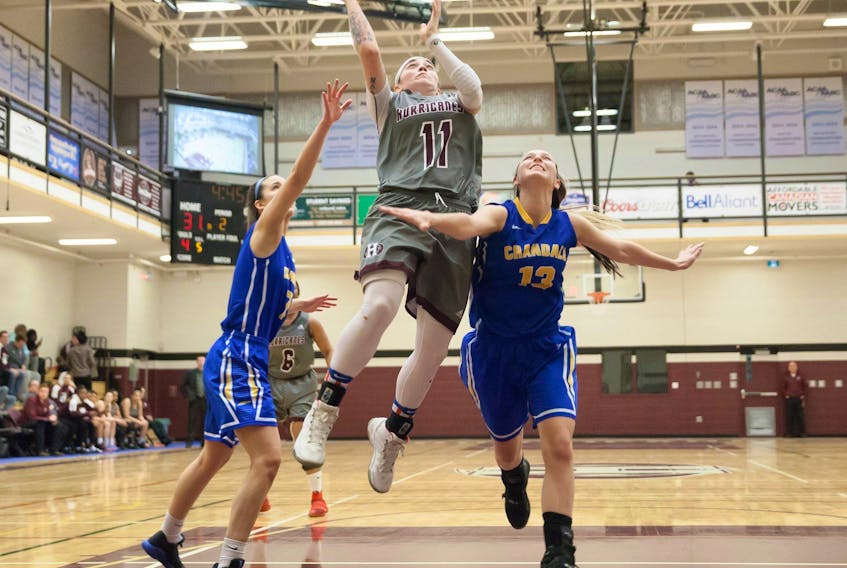 Breauna Rivoli-Johnson of the Holland Hurricanes drives to the basket against the Crandall Chargers’ Sydnee Balser, 13, and Grace Daniels. The Hurricanes won the Atlantic Collegiate Athletic Association women’s basketball game in Charlottetown 92-63. Mike Bernard Photography