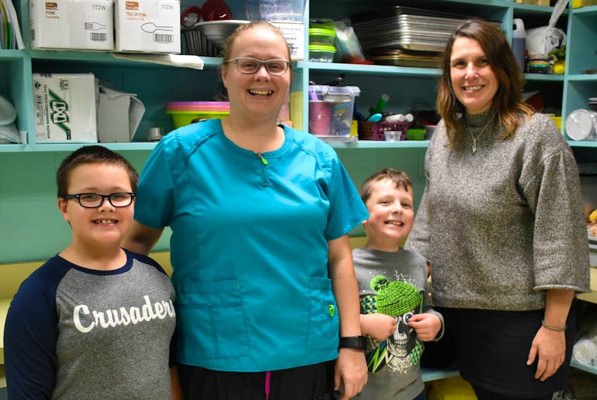 Karen Murchison from P.E.I. Certified Organic Producers Co-operative and Bev Campbell, vice-president of Home and School at Queen Elizabeth Elementary School with Queen Elizabeth Grade 3 students Braxton Campbell and Wyatt McCormick.