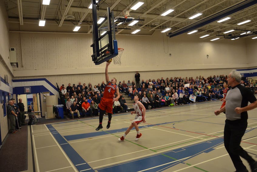 Tyler Newson of the East Wiltshire Warriors charges to the basket for a lay-up while the Athena Hawks’ Spencer Rossiter hustles back on defence. The action took place during the boys’ gold-medal game of the P.E.I. School Athletic Association intermediate AA basketball championships at Summerside Intermediate School on Tuesday night. Newson was named the provincial championship tournament’s most valuable player. East Wiltshire won the final 80-55.
