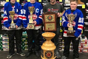Dwayne McNeill, son of the late Edd McNeill, and three members of the Summerside Capitals, Carson Griffin, left, Lincoln Waugh, second left, and Brewer Waugh check out some of the hardware that is up for grabs in the 21st annual Edd McNeill Memorial hockey tournament. Nine peewee AAA teams from across the Maritimes are taking part. Play begins at The Plex in Slemon Park on Thursday evening, and concludes on Sunday afternoon.
