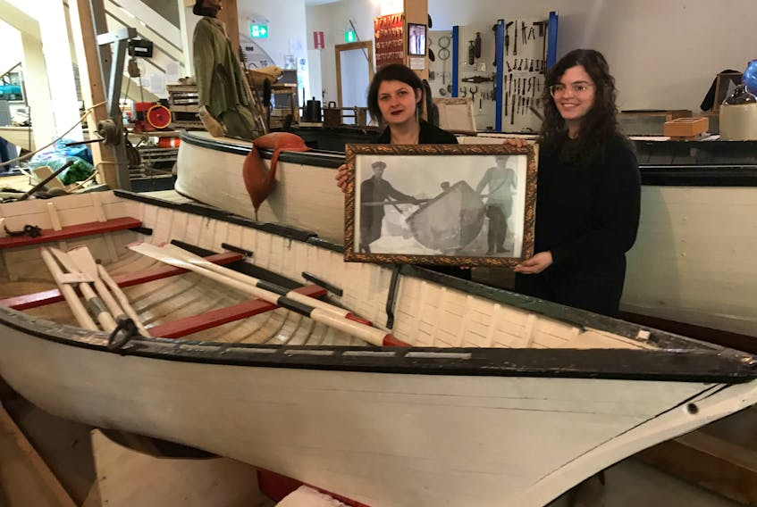 Victoria Bailey Thompson, left, manager and curator of the Northumberland Fisheries Museum, and Morgan Baillie, summer student with the Pictou Island Heritage Society, stand beside the Pictou Island ice boat that is in the process of being returned to the Island.