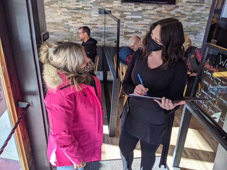 Waitress Kaitlyn Henderson (right) takes Jessica Totten’s contact information at the Nook and Cranny in downtown Truro.
