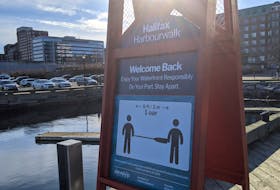 A sign reminding people to social distance is seen on the Halifax Waterfront. - File