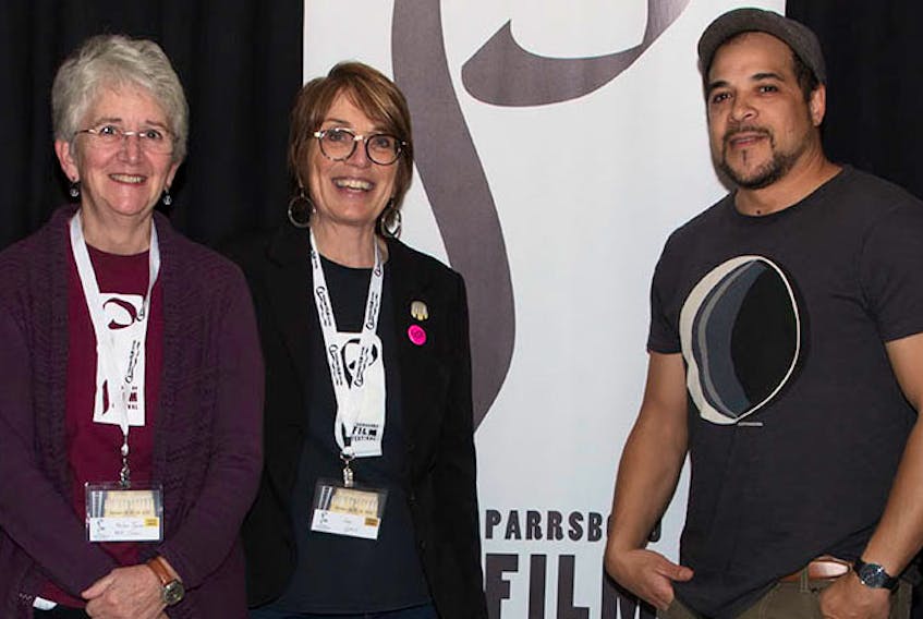 (From left) Helen Tyson, Lori Lynch and Corey Bowles, who showed his film Bad Cop last year, look over photos from the eight Parrsboro Film Festival in 2018. The ninth edition of the popular community festival is set for Oct. 25 to 27 at The Hall in Parrsboro. Lawrence Nicholl photo.