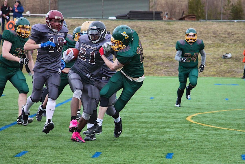 Island Mariners running back Dillon Fortune throws a stiff arm to a Southern New Brunswick Ducks defender during recent Maritime Football League action in Quispamsis, N.B. Tracey Barker/Special to The Guardian
