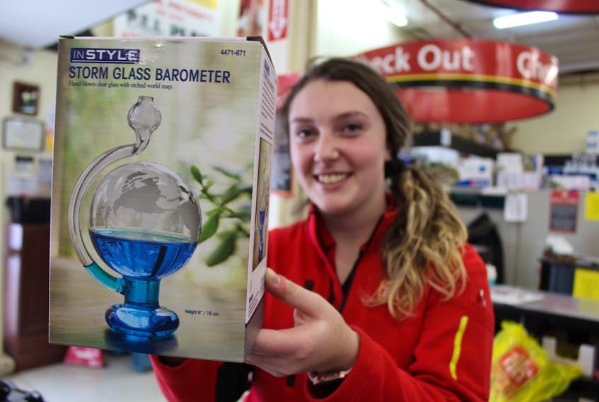 Callbecks Home Hardware employee Katie Pearce with an InStyle glass barometer. The weather predicting gadget has proven popular with Island weather watchers and most stores are sold out of them. Another employee had to bring in their own for this photo because the store has none.