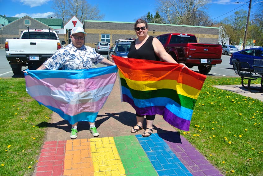 Cumberland Pride co-chairs Rogan Porter (left) and Emma Brown show the flags that will be celebrated during Pride Week festivities that run from June 10 to 16 in Amherst and Oxford.