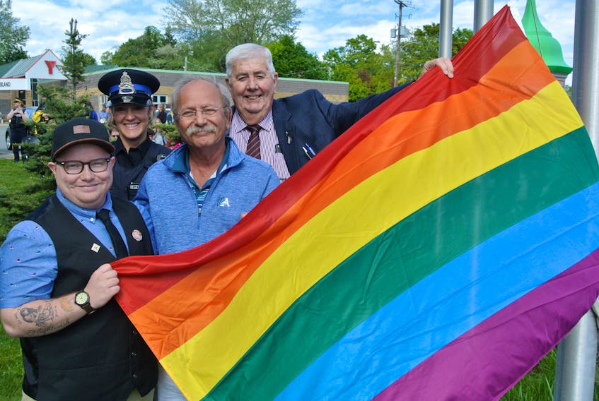 (From left) LGBTQ activist Rogan Porter joins Amherst Police Const. Michelle Harrison, Amherst Mayor David Kogon and Cumberland County Warden Allison Gillis in raising the Pride flag in Amherst on Monday.