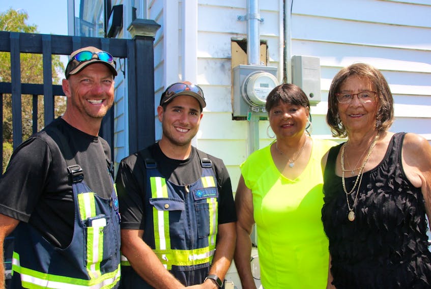 Truro Public Works employees Jason Rann, left, and Vernon Arndt, alerted Elizabeth Wilson and her mother Elenor Jones to a fire on the side of their house. The fire started in the power meter, which has been replaced.