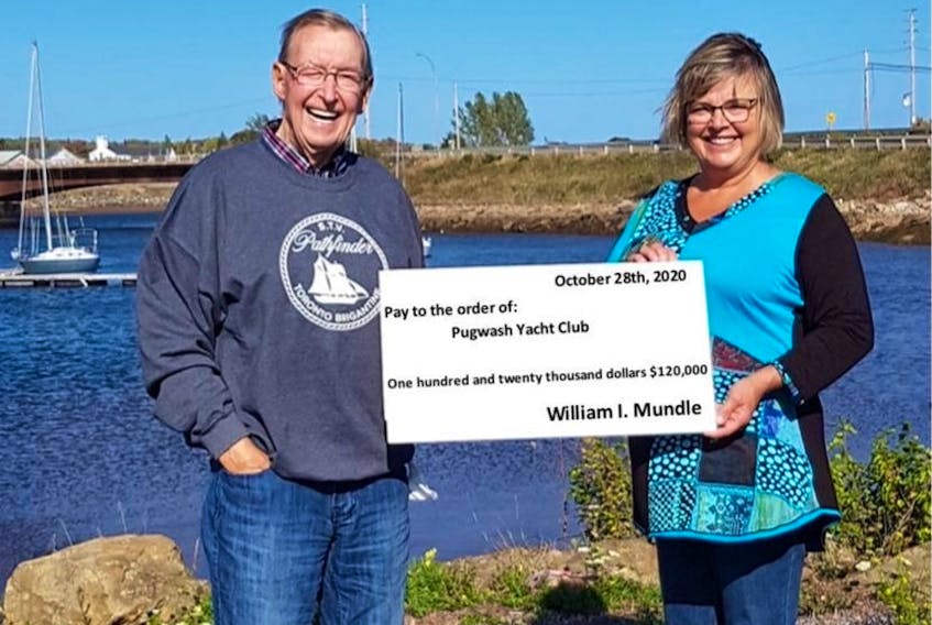 The Pugwash Yacht Club’s first commodore Bill Mundle presents a $120,000 cheque to its present commodore Debbie Cameron, who is also his daughter. The money will go into improvements to the marina and should help leverage funding from higher levels.