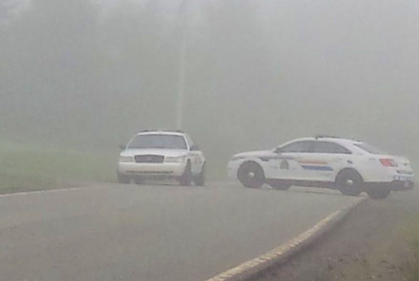 RCMP cars block a section of road on Highway 252 between Whycocomagh and Mabou on Saturday morning after a man was shot on Friday evening. Two men are now in custody in connection with the incident.
