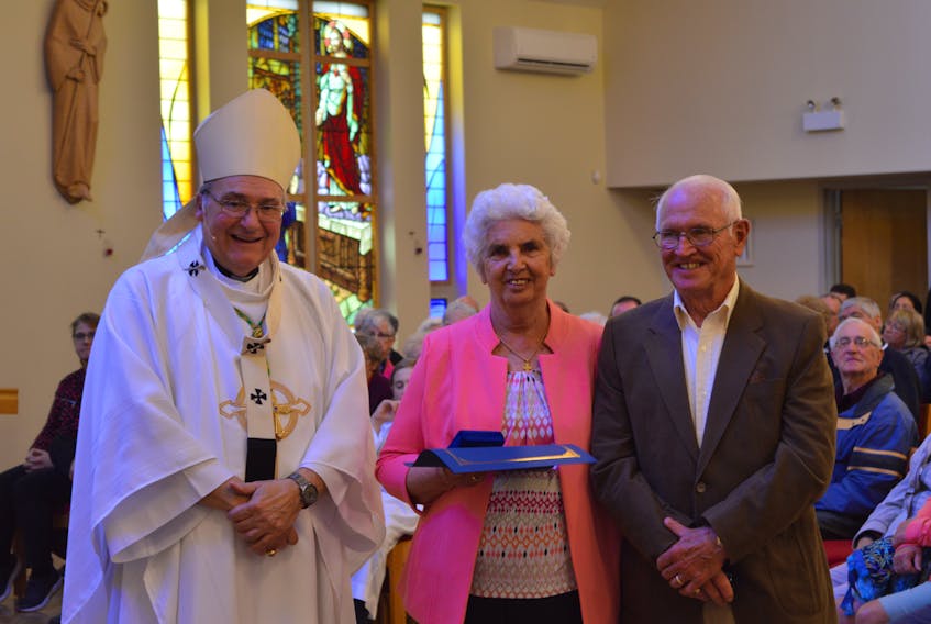 Archbishop Anthony Mancini presents the Archdiocesan Medal of Merit to Mary Lou Bourgeois of St. John the Baptist Church in Springhill, while her husband Jack Bourgeois looks on.