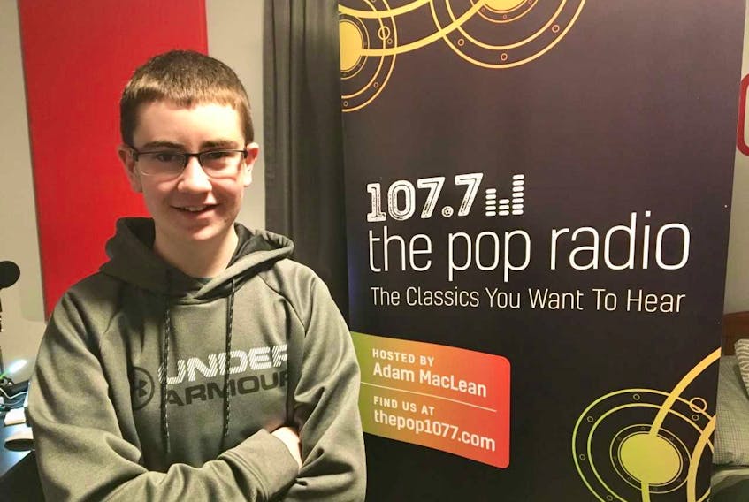 Adam MacLean stands near a banner in his bedroom promoting his radio station. The New Waterford native launched an online classic rock radio station last Monday and has already received positive feedback from listeners. MacLean is only 15-years-old.