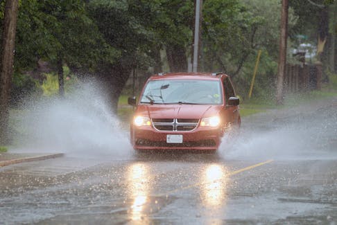 A car makes its way through some large puddles on North River Road Saturday. All of P.E.I. is under a rainfall warning.