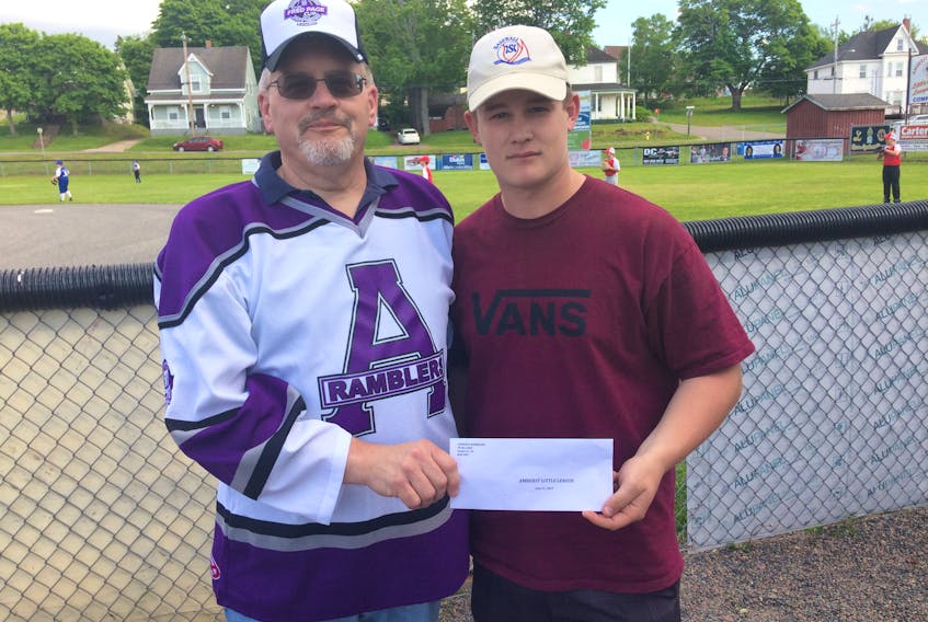 Amherst CIBC Wood Gundy Ramblers treasurer Allan Chapman (left) presents a $1,000 donation to Amherst Little League Baseball summer student Cole Stevens. Little League provides free baseball to children ages five to 12.