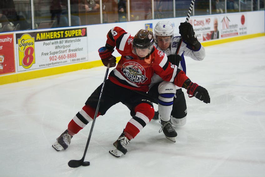 Harry Sanders of the Pictou County Weeks Crushers holds off Amherst CIBC Wood Gundy Ramblers defenceman Thomas Ashe in Maritime Junior Hockey League action on Saturday at the Amherst Stadium.