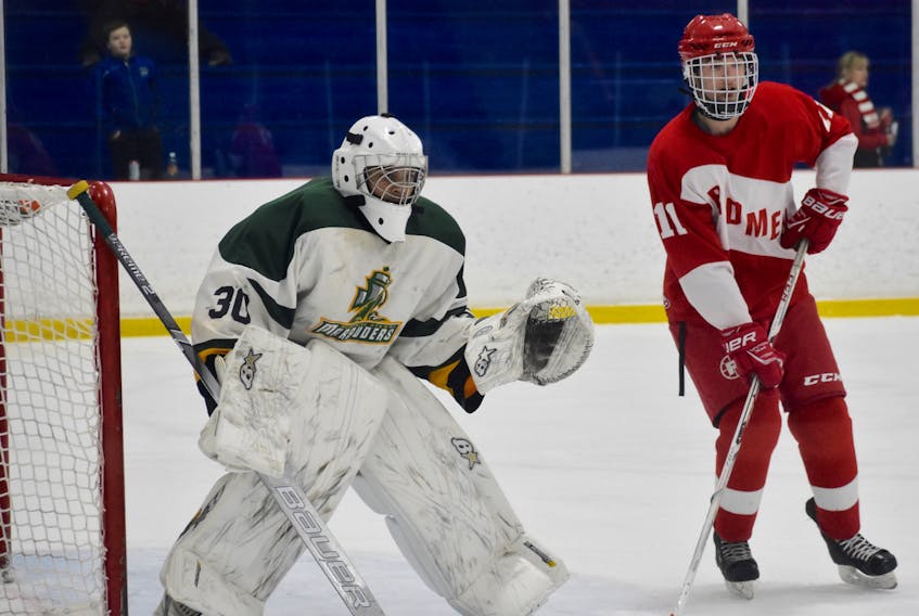 Jonathan Dolomont of the Memorial Marauders, left, and Carter Harnish of the Riverview Redmen watch the play during Cape Breton High School Hockey League action at the Cape Breton County Recreation Centre on Friday. The Redmen won the game 6-2.
