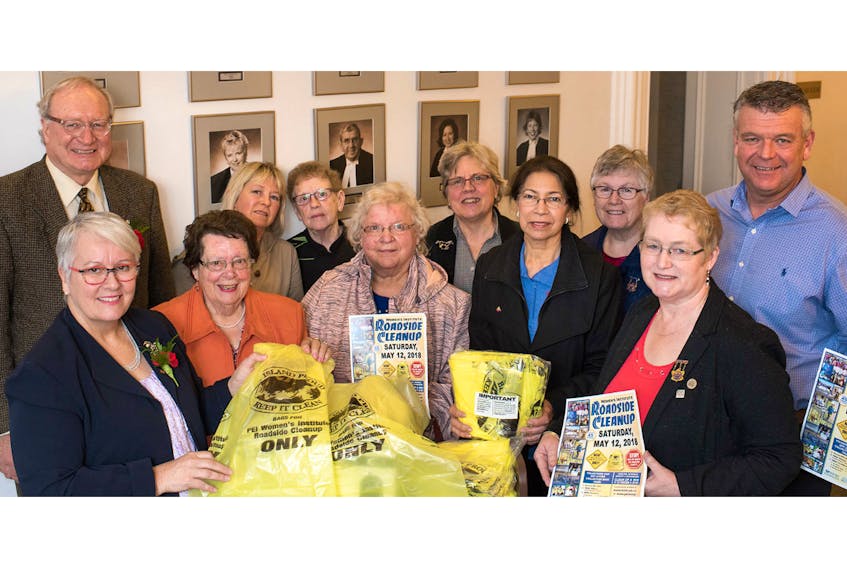 Tranportation Minister Paula Biggar, left, and Premier Wade MacLauchlan, along with members of the P.E.I. Women's Institute, display some of the specially marked yellow bags for the annual roadside cleanup on May 12, 2018.