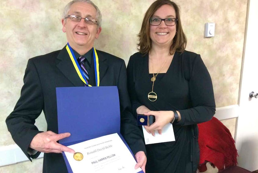 Ron Bickle accepts the Amherst Rotary Club’s Paul Harris Community Fellowship Award from club vice-president Trina Clarke during the club’s 84th anniversary dinner on March 11.