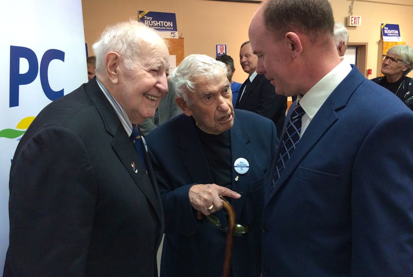 Former Nova Scotia premiers John Buchanan (left) and Roger Bacon (centre) speak to Cumberland South PC candidate Tory Rushton during a rally in Oxford on Saturday.