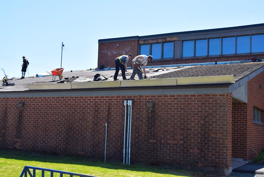 Workers with Gutter Done roofing contractors are seen stripping the shingles off a portion of the roof at Scotia Pool. The roofing job is one of four capital works projects remaining to be completed at the facility in the wake of reduced municipal funding.