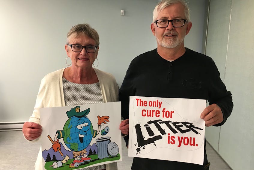 Marystown councillors Nora Tremblett and Mike Brennan, co-chairs of the protection to persons and property committee, hold up two anti-littering signs that will be placed on the town’s vehicles.
