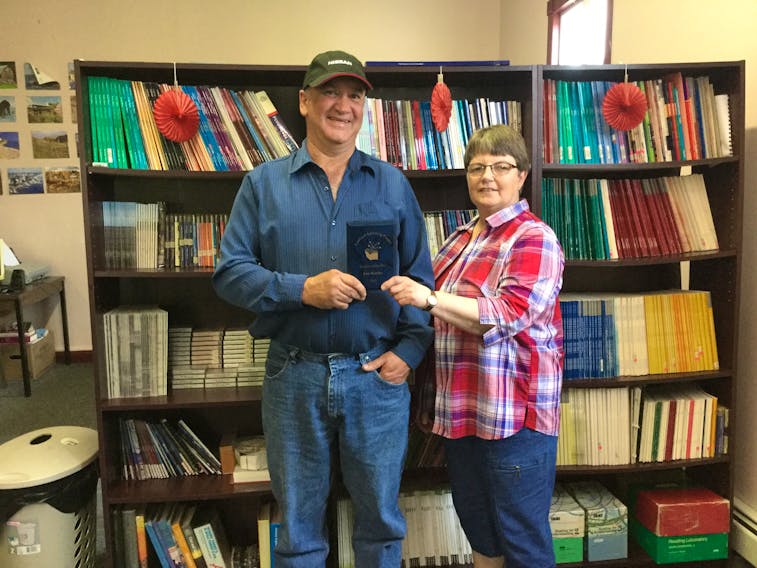 Eric Kearley (left) received a plaque and monetary award from Burin Peninsula Laubach Literacy Council member Sharon Manning.