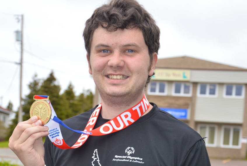 Lucas Antle displays one of the 18 medals he has won at Special Olympics competitions in the province.
