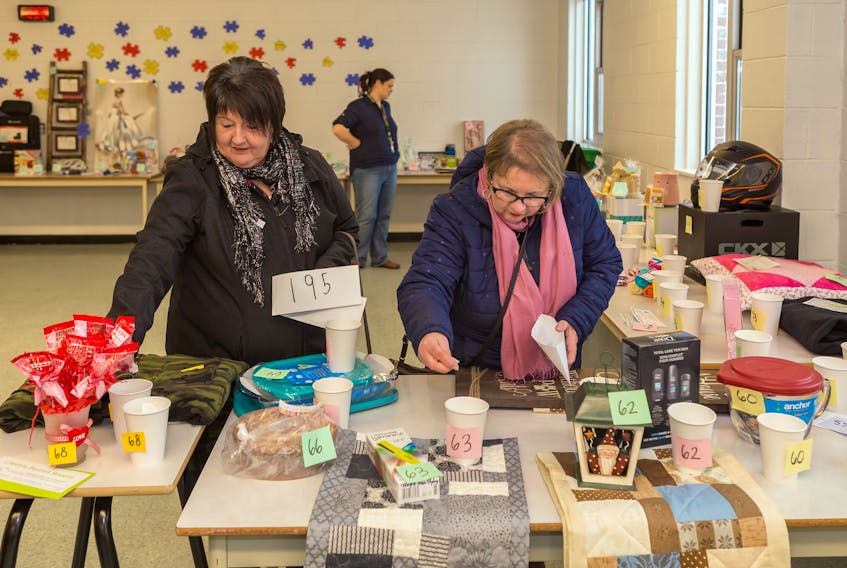 Doris Matterface, left, and Brenda Lake were two of many participants supporting the silent auction to raise money for the Burin Peninsula Autism Support Group. Carl Rose/ Special to The Southern Gazette