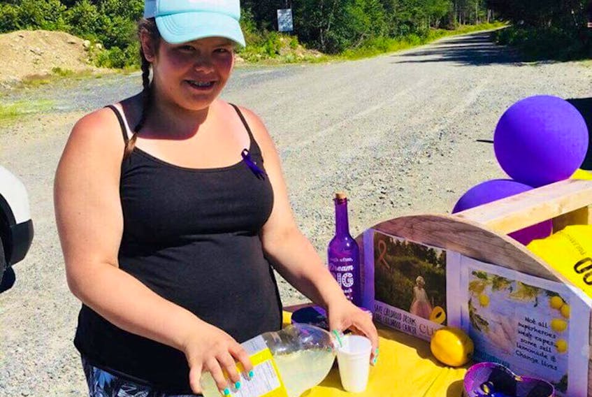 Jasmine Bolt pours up a glass of lemonade for passersby at a stand her family set-up just off the Burin Peninsula Highway on Saturday, Aug. 12.