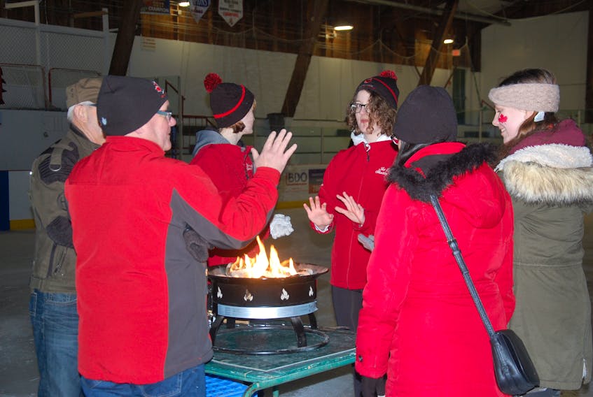Skaters warm up by the fire at center ice during a free skate at an Olympic viewing party in Marystown. Supporters gathered last night at the Kaetlyn Osmond Arena to watch the live broadcast of the ladies’ figure skating short program.
