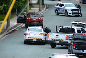 St. John's police shelter behind their vehicles at an apparent standoff scene on Craigmillar Ave. early Sunday morning. The RNC was called to the scene shortly after 4 a.m. and arrived to find the victim lying in the street, and a vehicle at the side of the road with the door open. Residents in the area were told to stay inside.