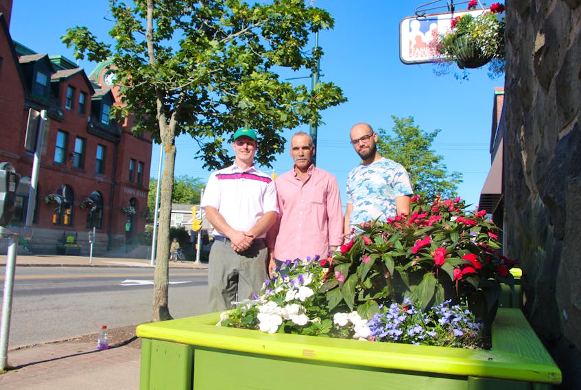 Ben Theuerkauf (left), Toufic al Zhouri and his son, Majd, with one of the planter boxes in the foreground, that Toufic and Ben built for the Town of Antigonish, on Main Street.